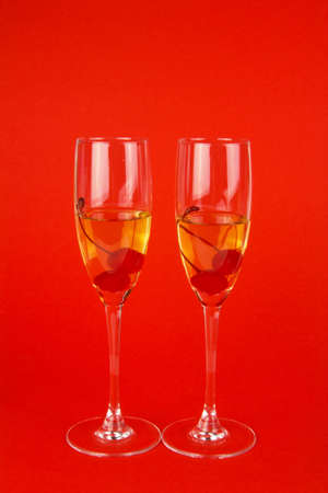 two glasses of champagne with cherries on the redの写真素材