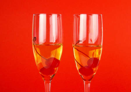 two glasses of champagne with cherries on the redの写真素材