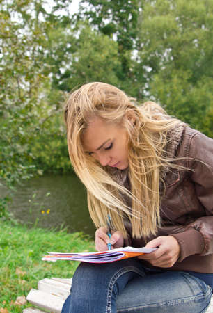 Woman writing in parkの写真素材