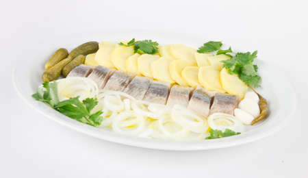 Plate with portion of herring fish fillets with potato and onionの写真素材