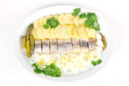 Plate with portion of herring fish fillets with potato and onionの写真素材