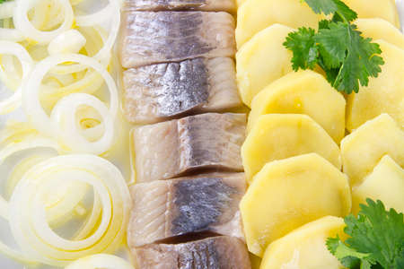 Portion of herring fish fillets with potato and onionの写真素材