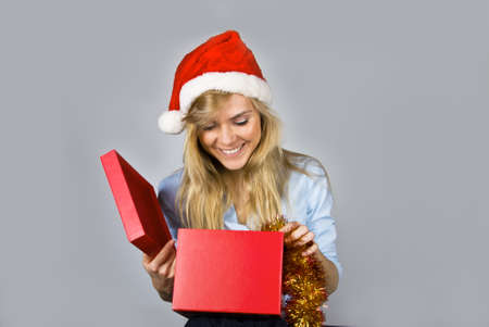 Young pretty young woman opens Christmas present