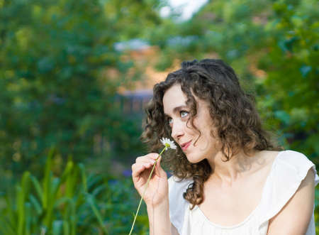 Young pretty woman with daisy flowerの写真素材