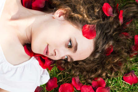 Young pretty woman in rose petalsの写真素材