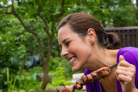 woman enjoying barbecue outdoorsの写真素材