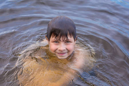Little boy swimming in a lakeの写真素材