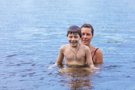 Mother and son swimming in the lakeの写真素材