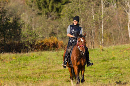 Elegant attractive woman riding a horseの写真素材
