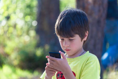 Child playing phone outdoors