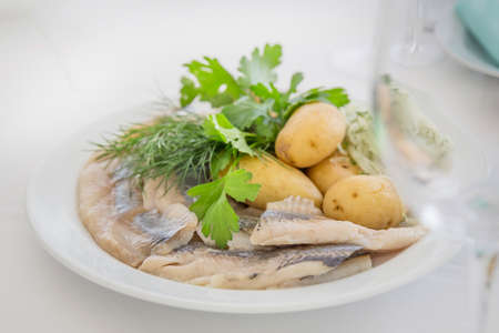 Portion of herring fish fillets with potato and onion on a plateの写真素材