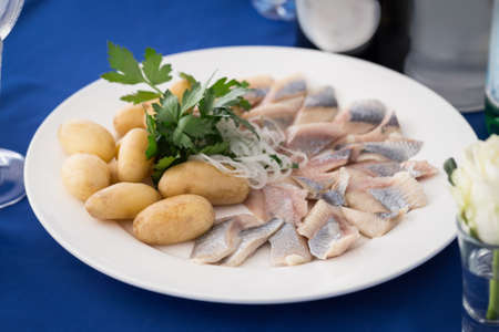 Portion of herring fish fillets with potato and onion