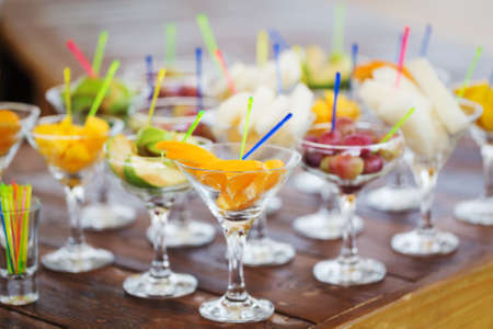 Fresh tasty fruit cuts in champagne glassesの写真素材