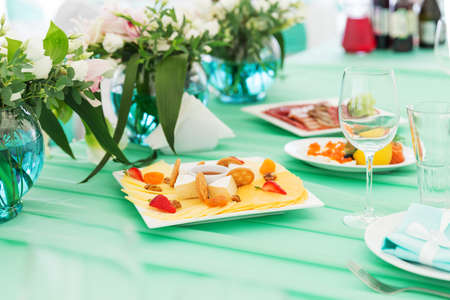 Party cheese board on a table with flowersの写真素材