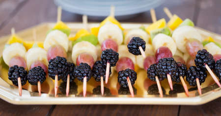 Fresh tasty fruit cuts and berries on picksの写真素材