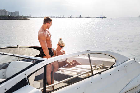 Elegant beautiful couple on a boat in a swim wearの写真素材