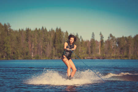 Young woman study riding wakeboarding on a lakeの写真素材