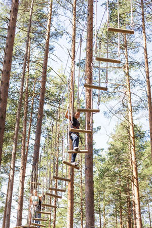 Young brave woman climbing in a adventure rope parkの写真素材