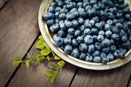 Fresh blueberries crop on a metal plate in gardenの写真素材