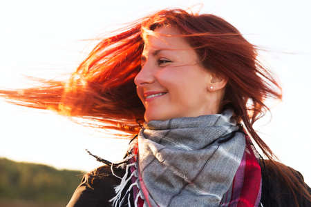 Woman with red hair have fun on the cost of the lakeの写真素材