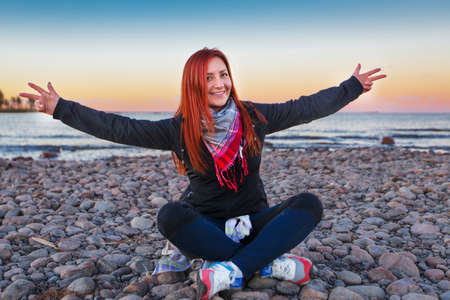 Woman on the cost of the lake in sunset lightsの写真素材