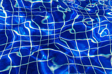 Water surface background in blue swimming pool outdoors