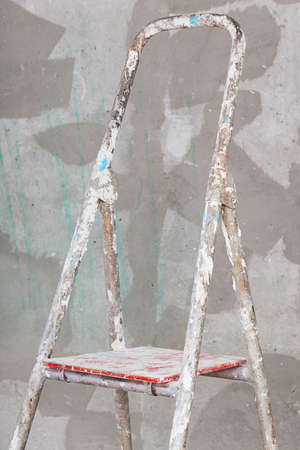 Old painted and stucco ladder on concrete wall backgroundの写真素材