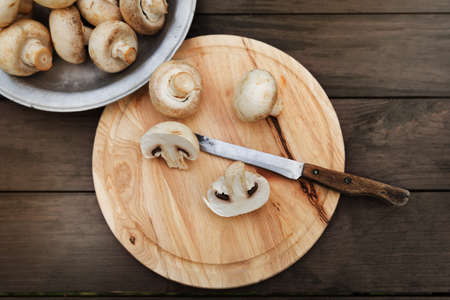 Fresh champignon mushhrooms on a wooden backgroundの写真素材