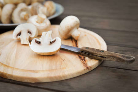 Fresh champignon mushhrooms on a wooden backgroundの写真素材