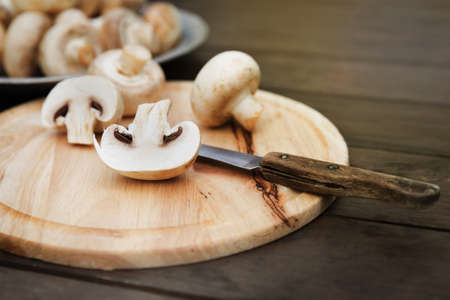 Fresh champignon mushhrooms on a wooden backgroundの写真素材