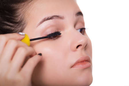 Young woman applying mascara - Makeup make-up close