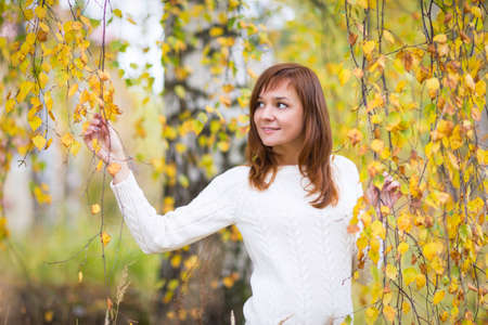 Pretty woman in a colorful autumn parkの写真素材
