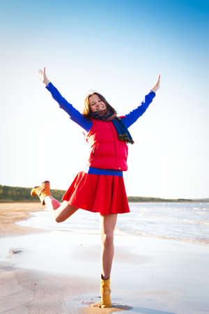 Woman in red have fun on the cost of the lakeの写真素材