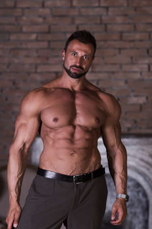 Strong healthy muscle man poses shows pressの写真素材