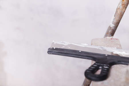 house improvement by worker puts finishing layer of stucco on the wall using a plastering trowelの写真素材