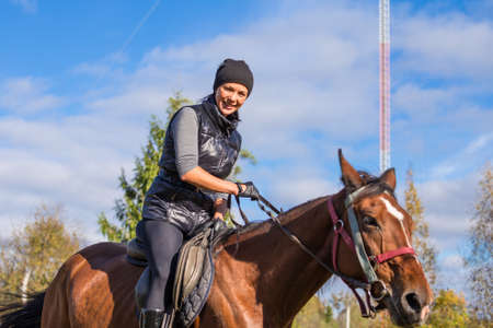 Elegant attractive woman riding a horse farmの写真素材