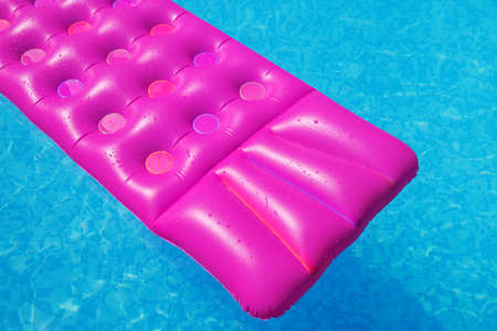 Pink air mattress in swimming pool. Holiday tropical background.の写真素材