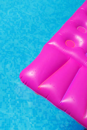 Pink air mattress in swimming pool. Holiday tropical background.の写真素材