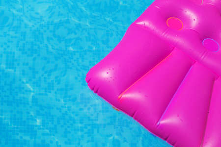 Pink air mattress in swimming pool. Holiday tropical background.の写真素材