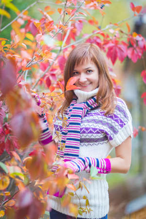 Pretty brunette woman in a bright colorful autumn parkの写真素材