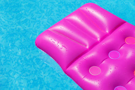 Pink air mattress on a swimming pool - holiday tropical background conceptの写真素材