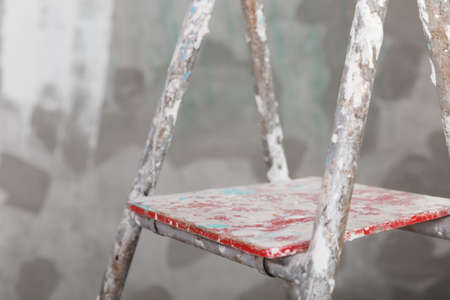 Old painted and stucco ladder on a concrete wall backgroundの写真素材