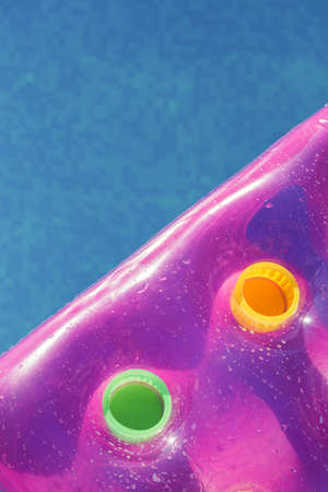 Pink air mattress on a swimming pool - holiday tropical background conceptの写真素材