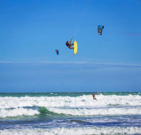 Athletic man jump on kite surf board in a sea wavesの写真素材