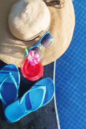 Watermelon fresh juice smoothie drink glass with flower, sunglasses near swimming poolの写真素材