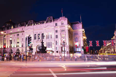United Kingdom, England, London - 2016 June 17: Popular tourist Picadilly circus with flags union jack in night lights illuminationのeditorial素材