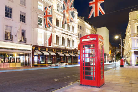 United Kingdom, England, London - 2016 June 17: Popular tourist Red phone booth with flags union jack in night lights illuminationのeditorial素材
