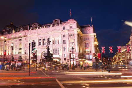 United Kingdom, England, London - 2016 June 17: Popular tourist Picadilly circus with flags union jack in night lights illuminationのeditorial素材