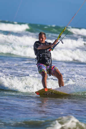 Athletic man jump on kite surf board on a sea wavesの写真素材