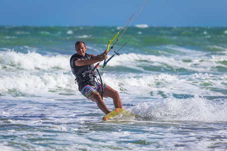 Athletic man jump on kite surf board on a sea wavesの写真素材